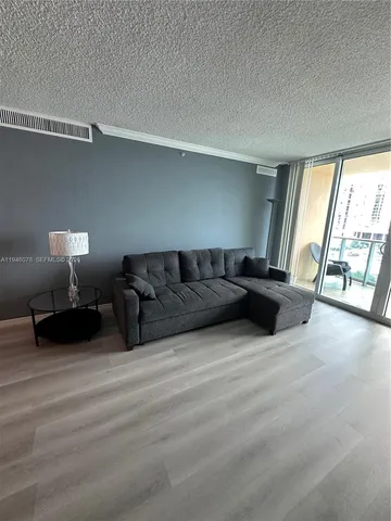 a living room with furniture a bed and a large window