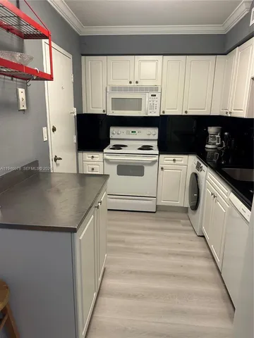 a kitchen with stainless steel appliances a stove a sink and white cabinets