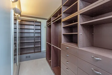 a view of walk in closet with empty racks