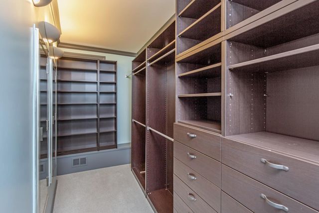 a view of walk in closet with empty racks