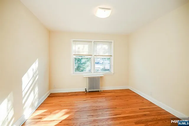 a view of a room with wooden floor and a bathroom