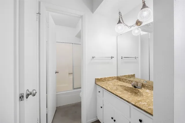 a bathroom with a granite countertop sink and vanity