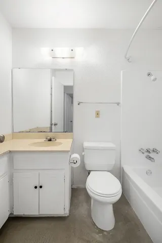 a bathroom with a toilet a sink and mirror