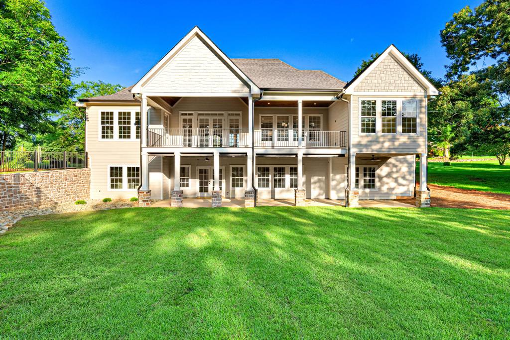 707 Vickery Street Extension Hartwell, GA 30643 - Photo 41 of 50 A grand rear elevation features dual covered balconies overlooking a vibrant lawn and natural stone retaining wall.