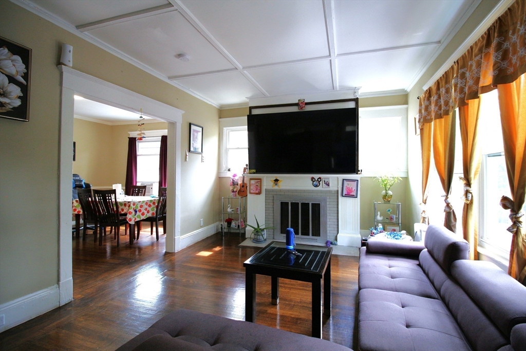 61 Kimberly Avenue Springfield, MA 01108 - Photo 17 of 39 a living room with furniture a flat screen tv and a fireplace