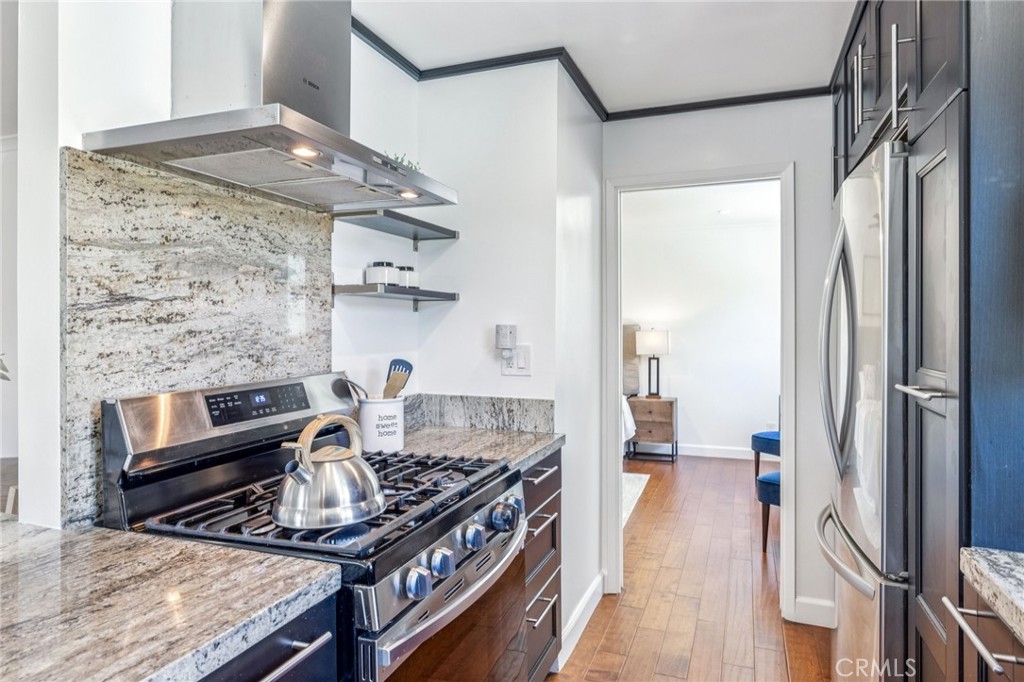 2015 Bataan Road, Unit 102 Redondo Beach, CA 90278 - Photo 12 of 43 a kitchen with stainless steel appliances granite countertop a stove and a refrigerator
