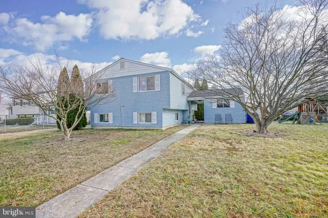 a front view of a house with a yard covered in snow