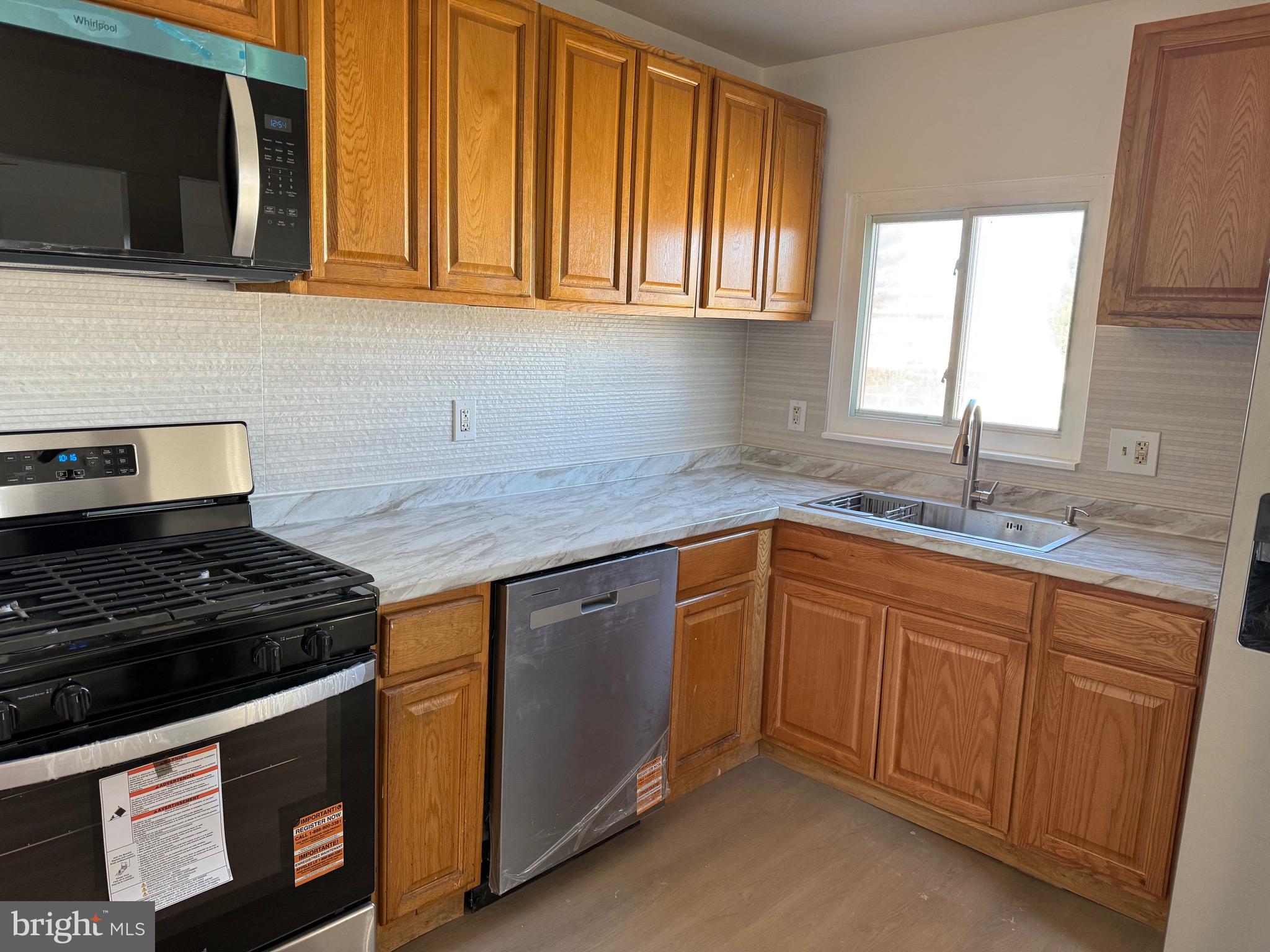 220 College Drive Pemberton, NJ 08068 - Photo 3 of 11 a kitchen with stainless steel appliances granite countertop a sink stove and microwave