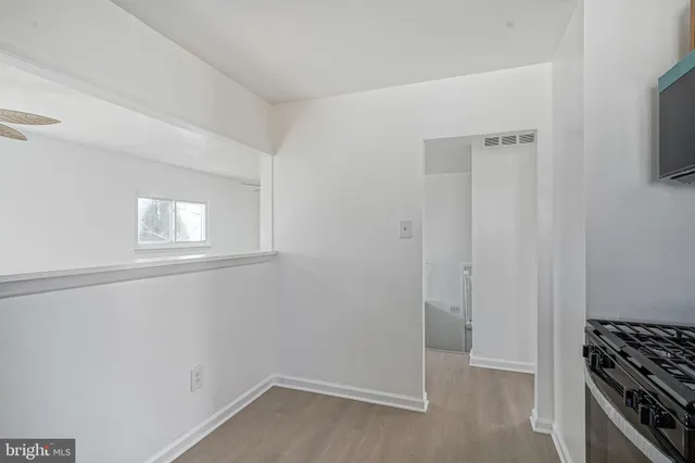 a view of a kitchen with white cabinets and wooden floor