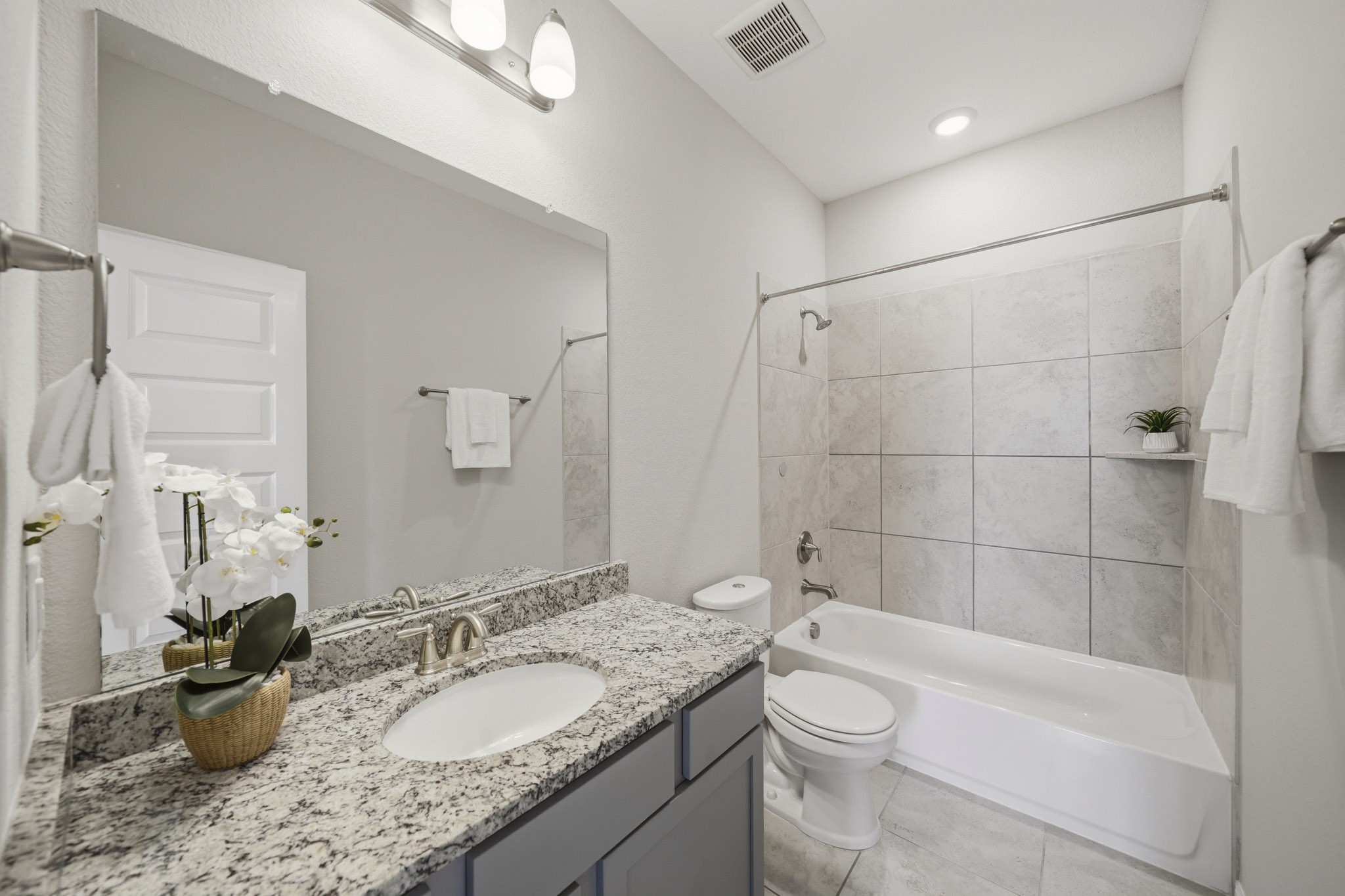 4103 Tranquil Square Road Houston, TX 77043 - Photo 29 of 39 Beautifully appointed, the secondary bath featuring tile floors, a granite-topped vanity, an elegant light fixture has a tub-shower combination with tile surround.