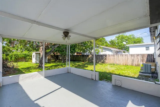 a view of a backyard with couches plants and large tree