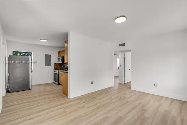 a view of empty room with wooden floor