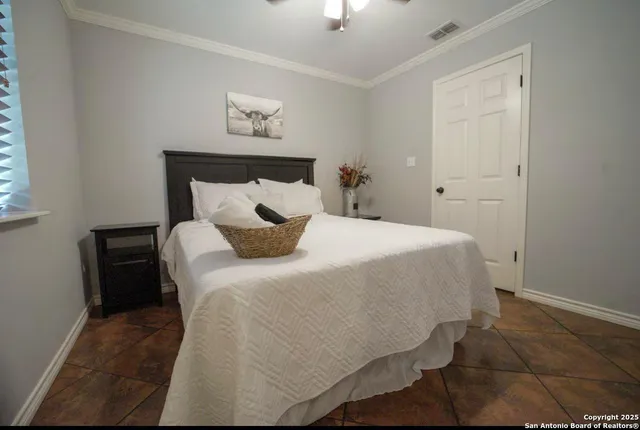 a bedroom with a bed and a lamp on the dresser