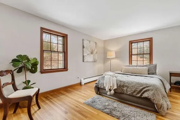 a spacious bedroom with a bed table chair and a window