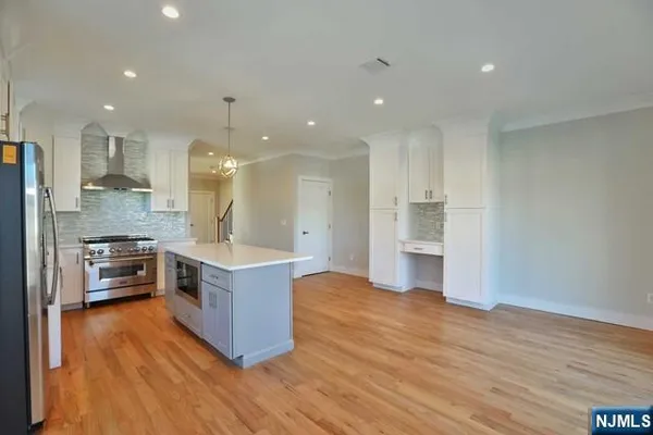 a large kitchen with stainless steel appliances granite countertop a large counter top and a stove top oven