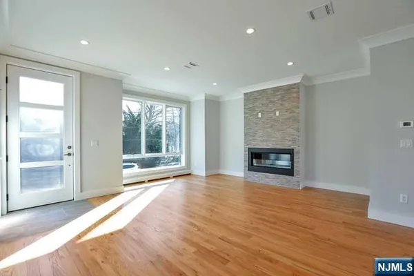 a view of an empty room with a window and a fireplace