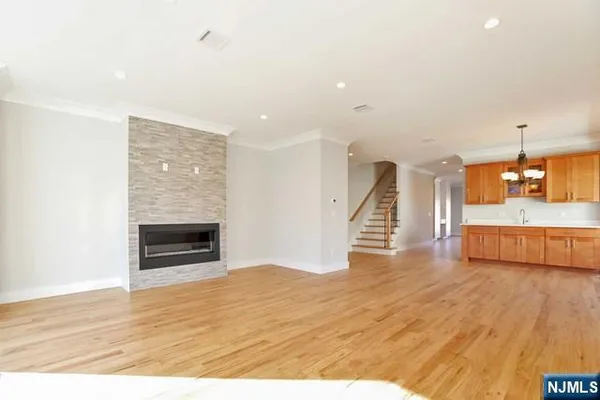 a view of empty room with wooden floor and fireplace