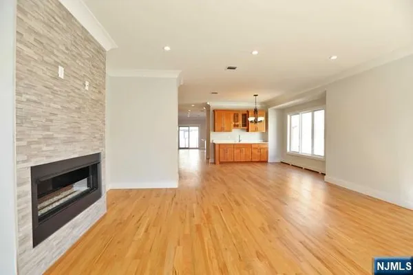 a view of empty room with wooden floor and fireplace