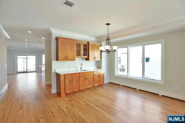 a large kitchen with stainless steel appliances granite countertop a oven a stove and a wooden floors