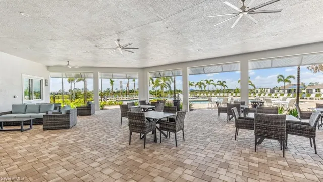 a room with lots of tables a large window and chairs