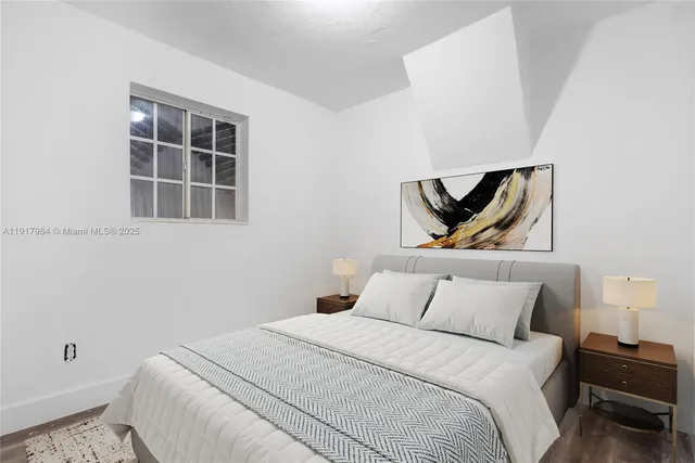 a bedroom with a bed and painting on the wall