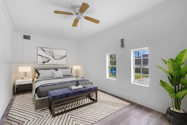 a bedroom with a bed wooden floor and window