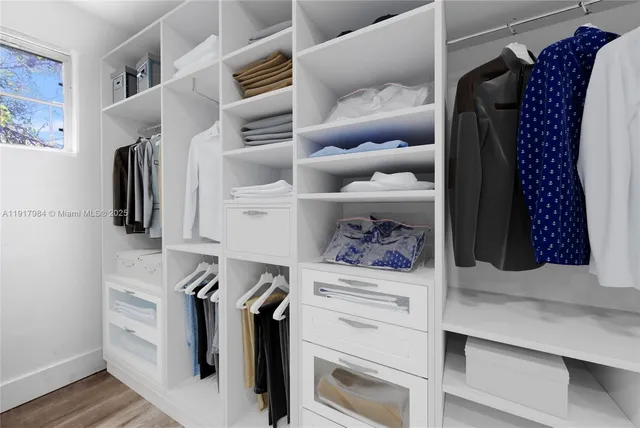 a view of walk in closet with clothes and shoes