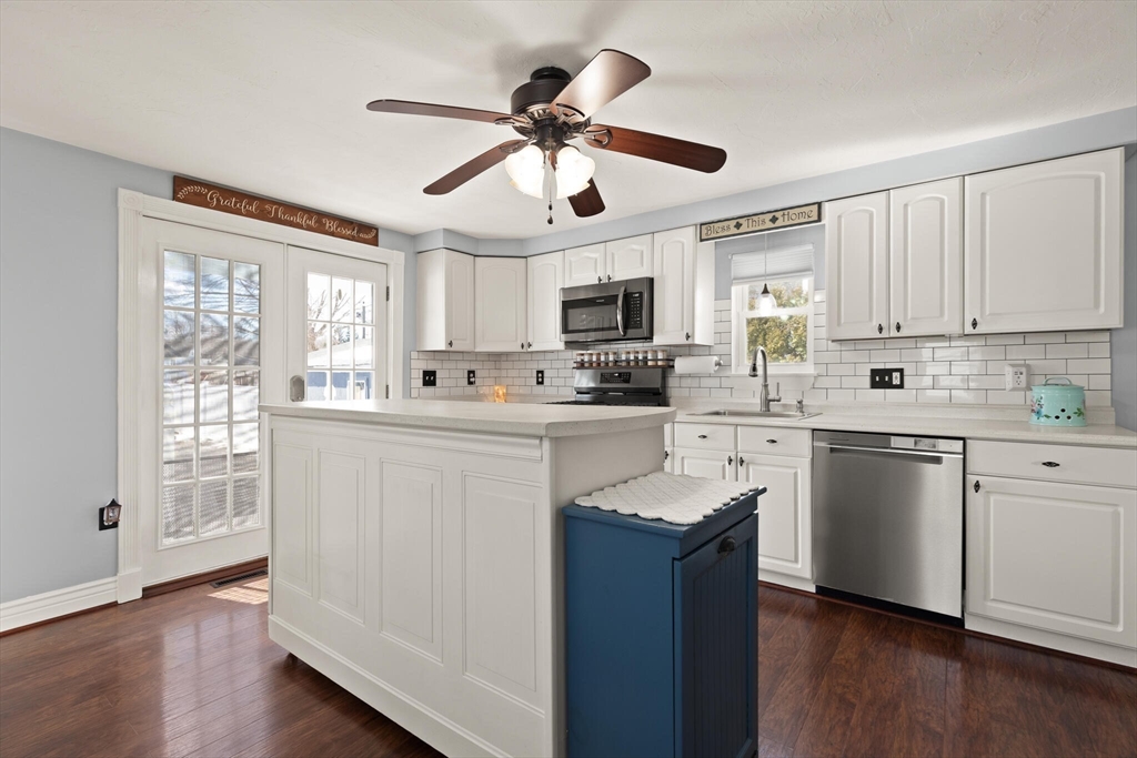 19 Cherry Street Hudson, MA 01749 - Photo 11 of 28 a kitchen with stainless steel appliances granite countertop a stove a sink dishwasher a refrigerator with white cabinets and wooden floor