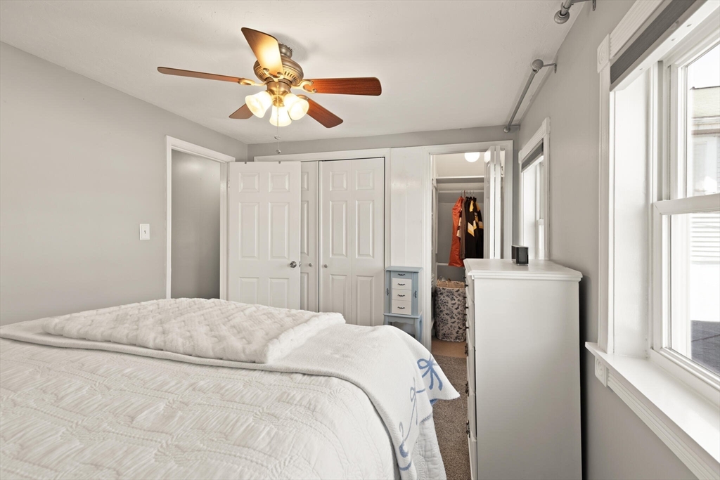 19 Cherry Street Hudson, MA 01749 - Photo 22 of 28 a bedroom with a large bed and a chandelier