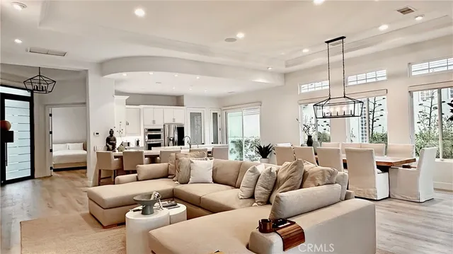 a living room with furniture chandelier and a large window