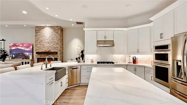 a large white kitchen with stainless steel appliances