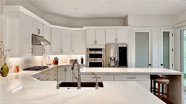 a kitchen with stainless steel appliances kitchen island granite countertop a sink and cabinets