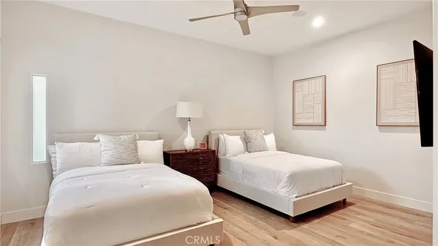 a bedroom with two beds and painting on the wall