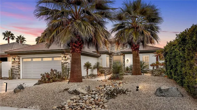a front view of a house with a tree