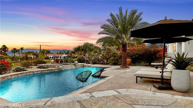 a roof deck with table and chairs under an umbrella