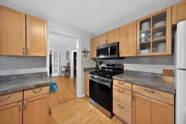 a kitchen with stainless steel appliances granite countertop a stove a sink and a microwave