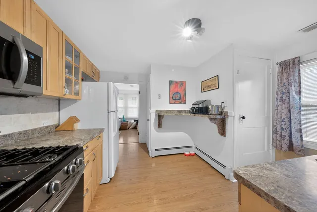 a kitchen with granite countertop a stove and a wooden floors