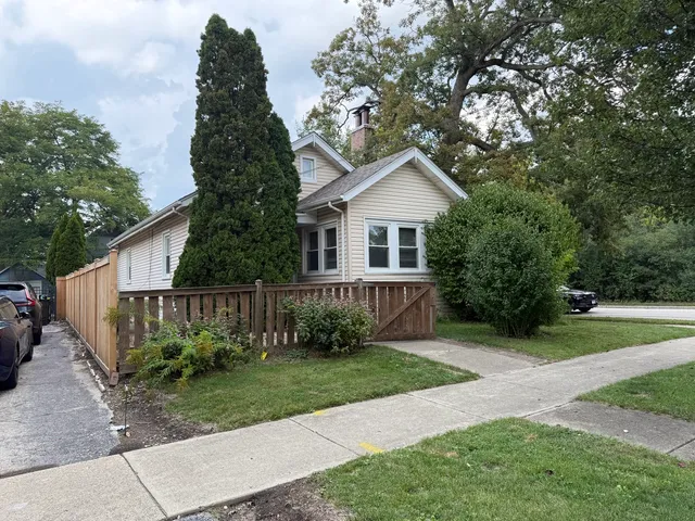 a view of a house with a yard and potted plants
