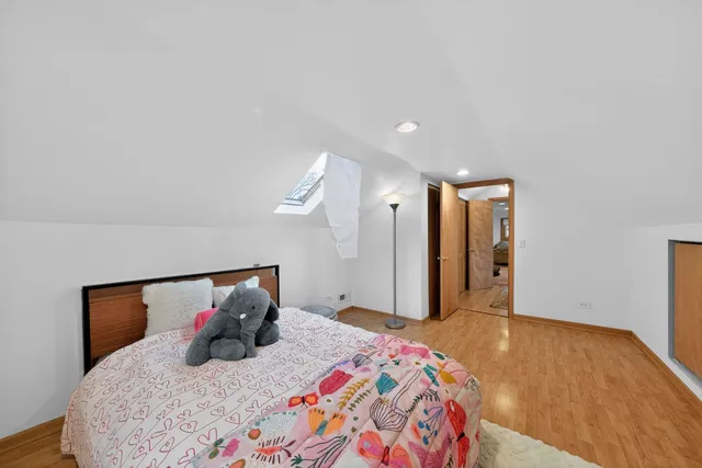 a bedroom with a large bed and wooden floor