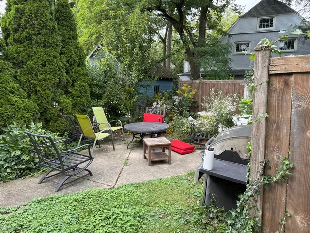 a view of a chairs and table in backyard