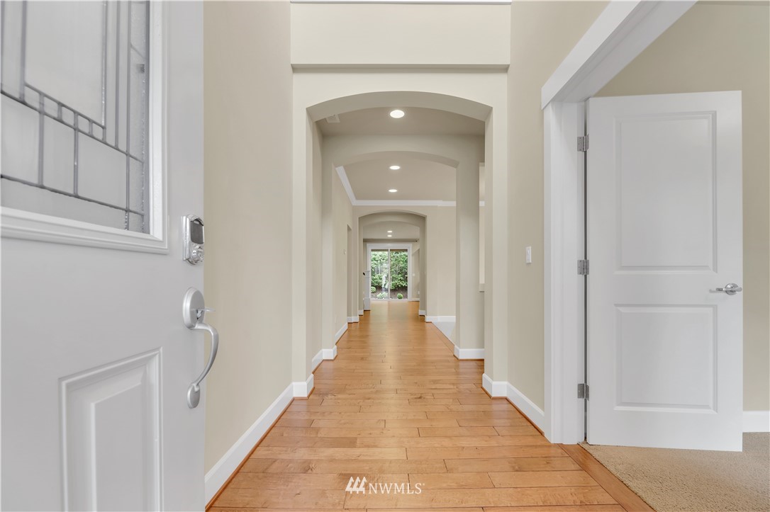 6117 Northeast 1st Street Renton, WA 98059 - Photo 2 of 39 a view of a hallway with wooden floor and staircase