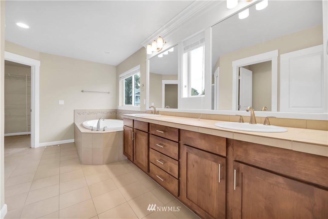 6117 Northeast 1st Street Renton, WA 98059 - Photo 18 of 39 a large bathroom with a large tub sink and mirror