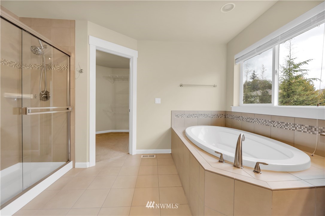 6117 Northeast 1st Street Renton, WA 98059 - Photo 19 of 39 a bathroom with a tub a sink and a large window