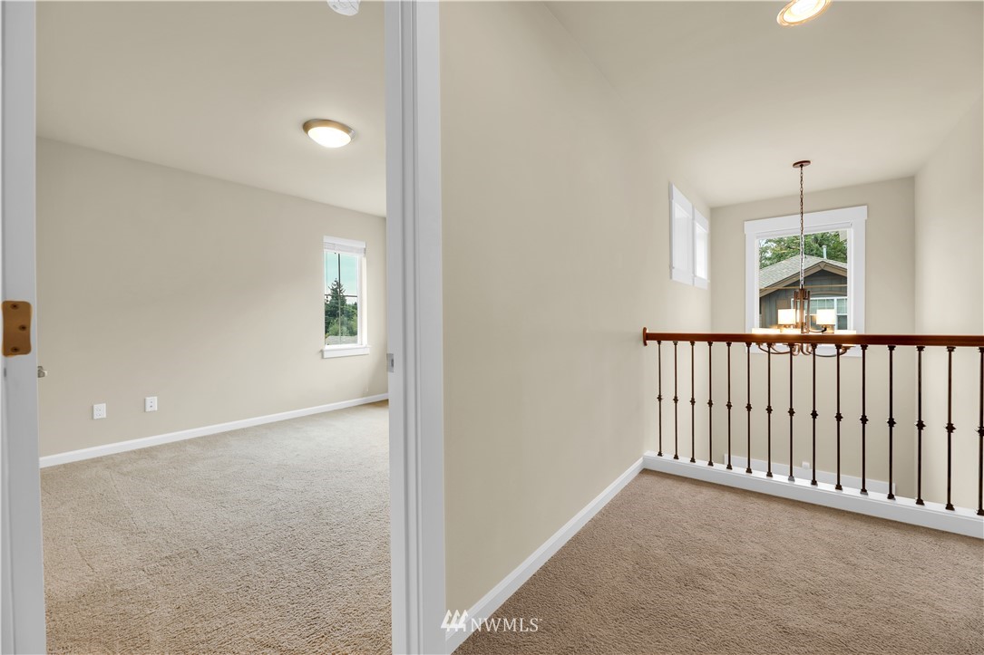 6117 Northeast 1st Street Renton, WA 98059 - Photo 27 of 39 a view of a hallway to a livingroom with furniture and window