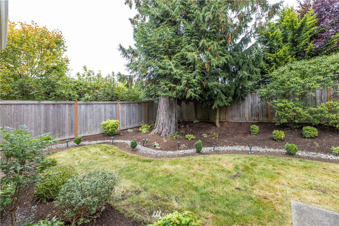 6117 Northeast 1st Street Renton, WA 98059 - Photo 32 of 39 a view of a backyard with table and chairs and wooden fence