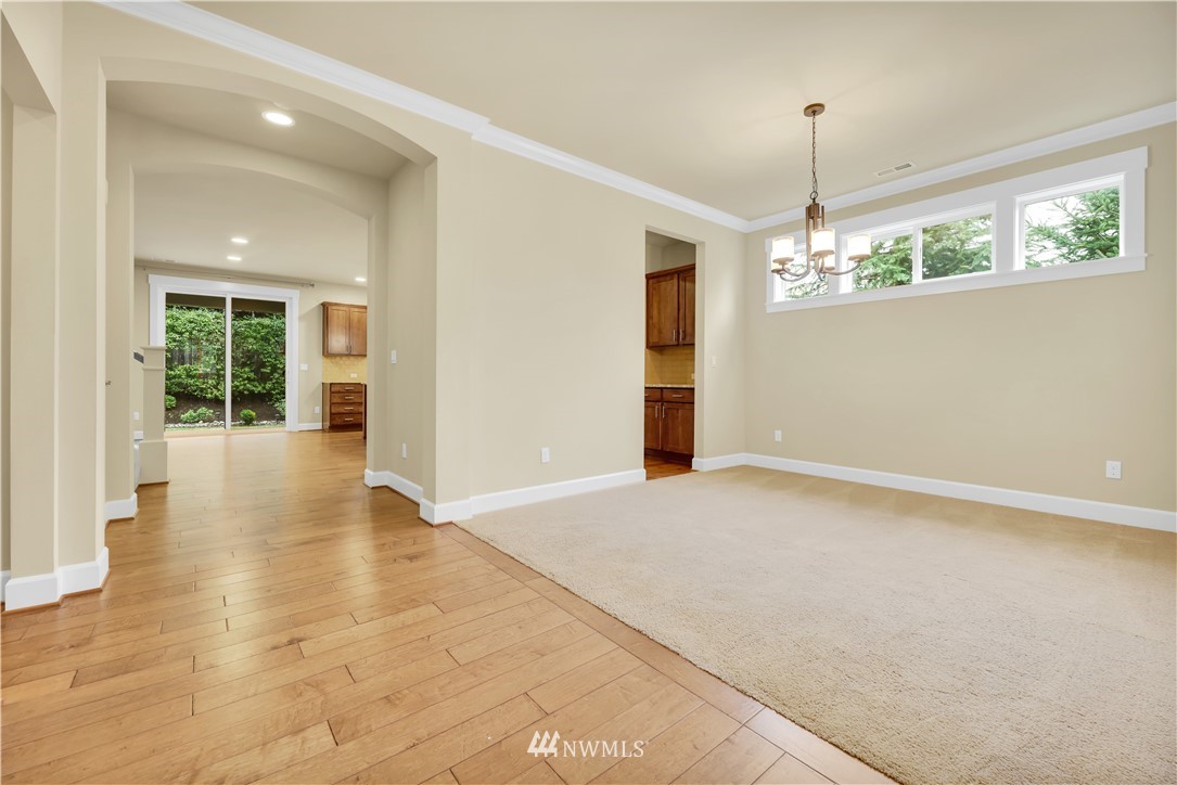 6117 Northeast 1st Street Renton, WA 98059 - Photo 5 of 39 a view of an empty room with wooden floor and a chandelier