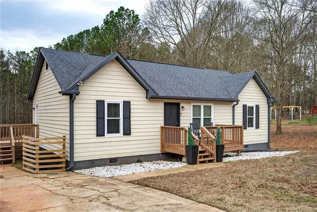 a view of a white house with large windows next to a road