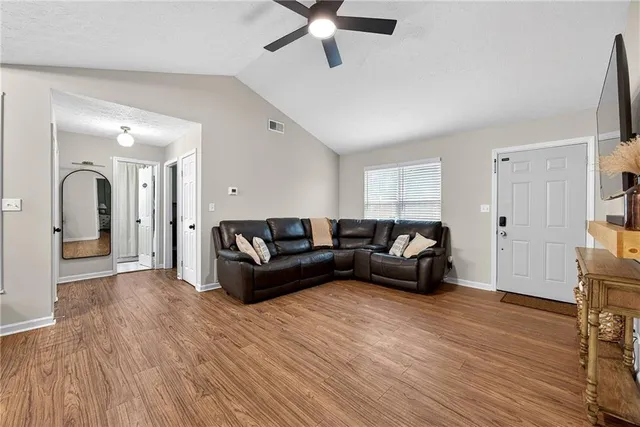 a living room with furniture and a wooden floor