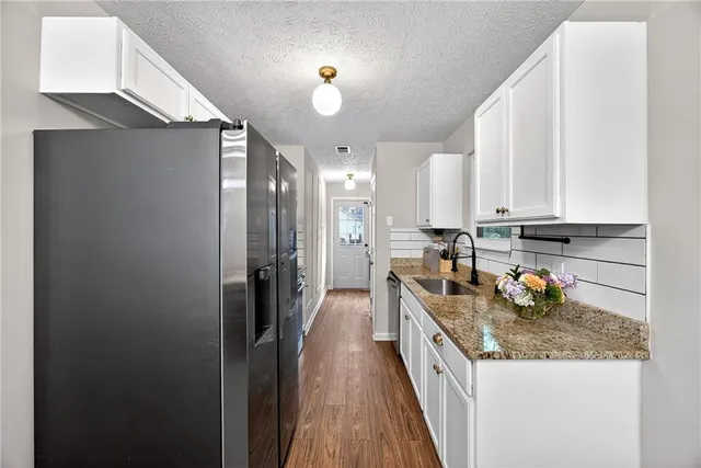 a kitchen with stainless steel appliances granite countertop a sink and cabinets