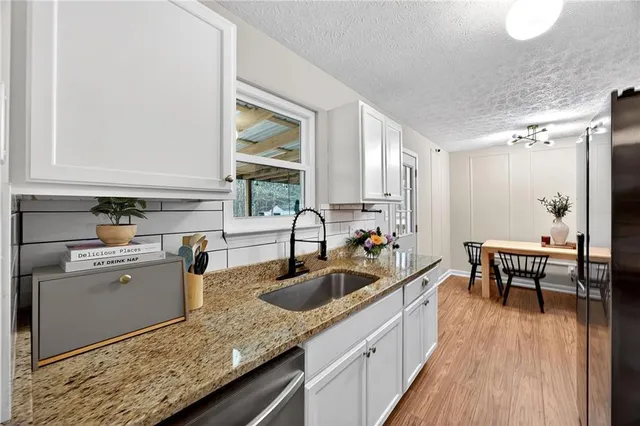 a kitchen with a sink a stove and cabinets